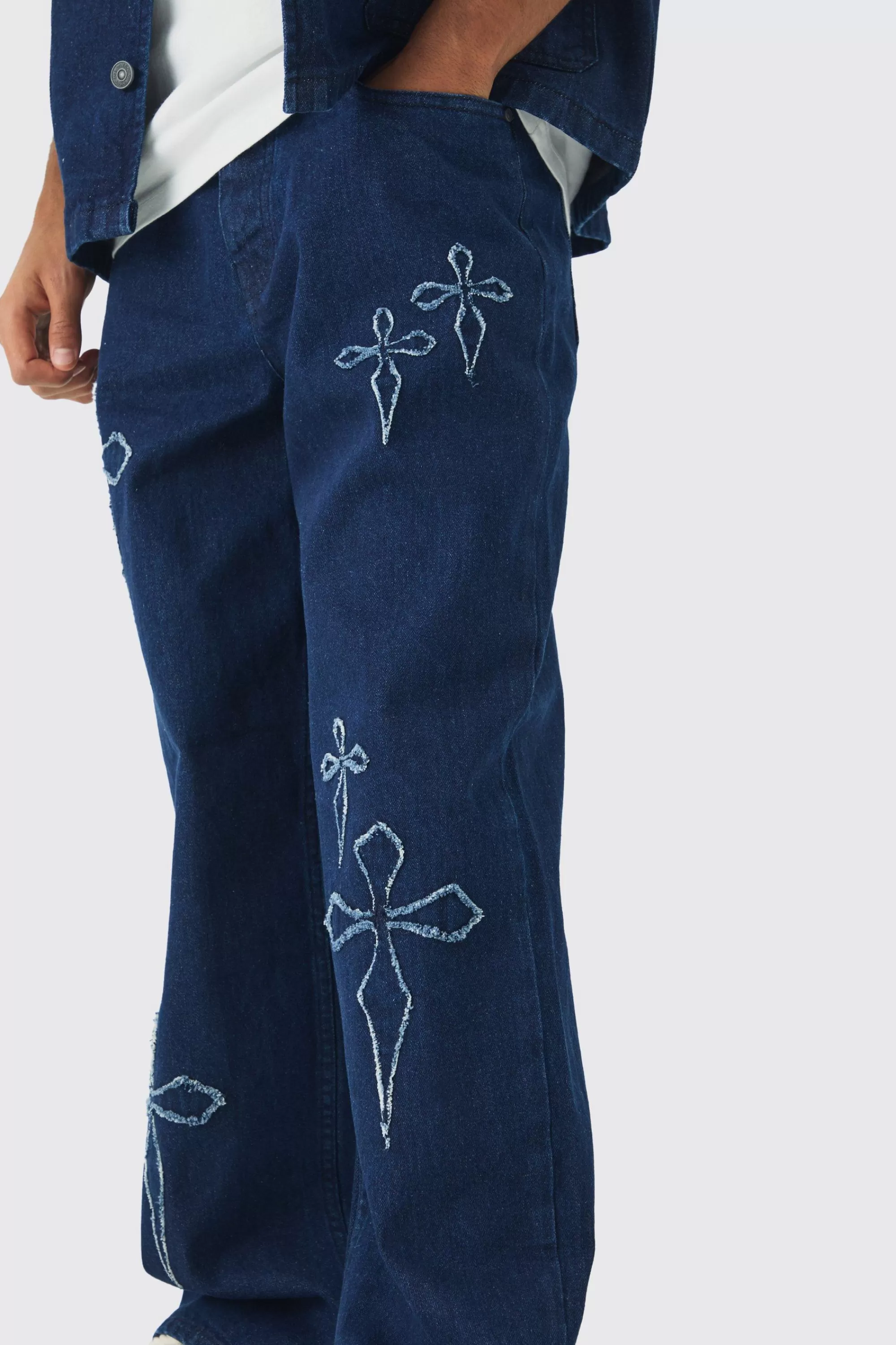 boohooMAN Baggy Fit Raw Edge Denim Cross Applique Jeans | UK